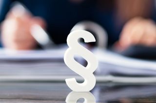 Foto: Paragraph vor Aktenmappe